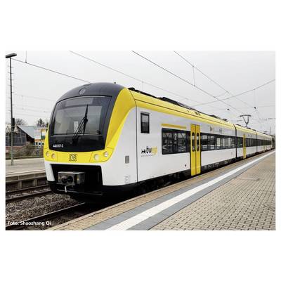 A yellow regional train with the inscription 'bwegt' is standing on the platform. Railway tracks and buildings can be seen in the background.
