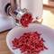 Fresh minced meat is being placed into a bowl from a mincing machine.