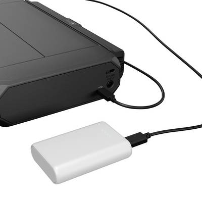 A black external hard drive is connected via a cable to a white power bank.