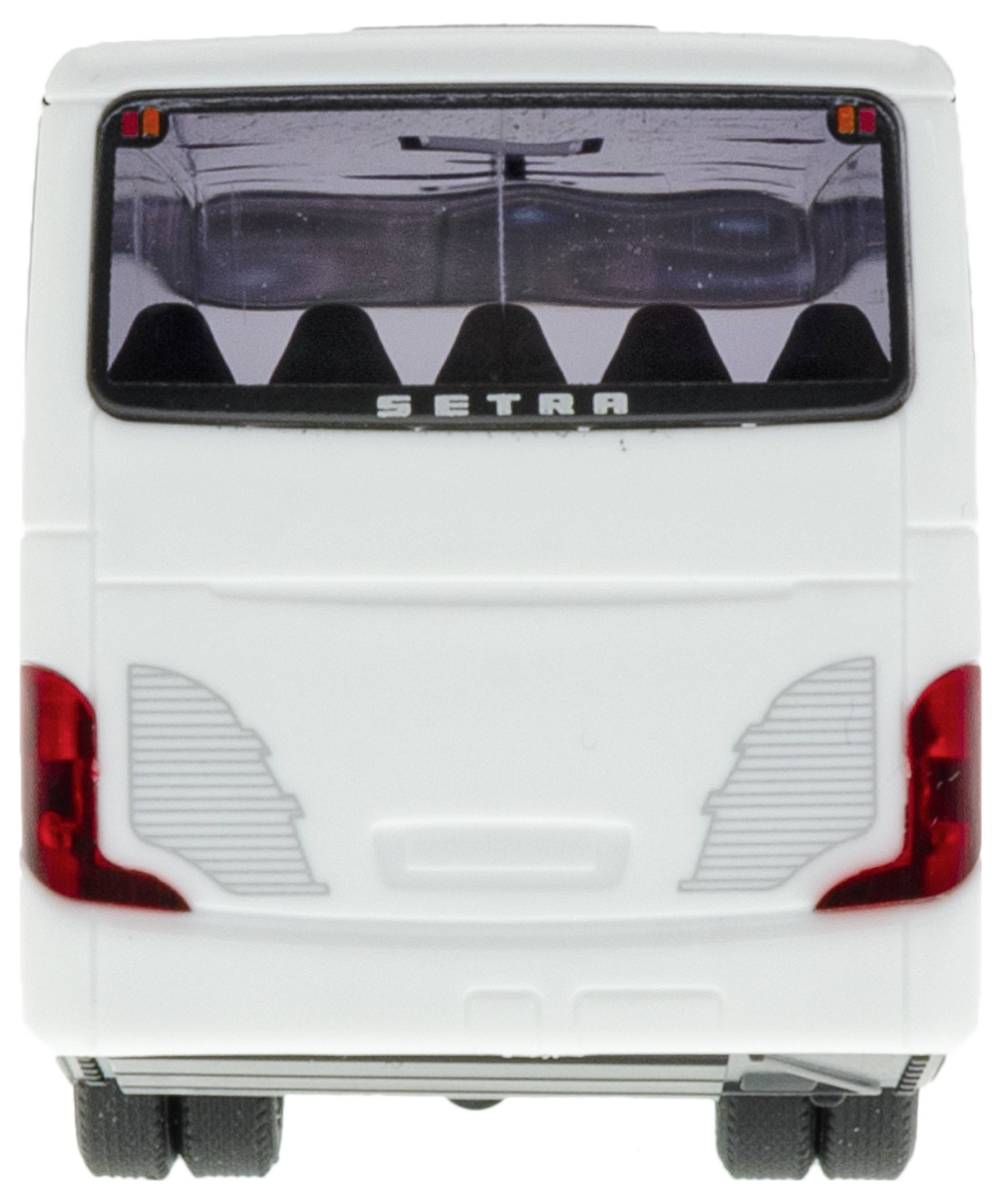 A white coach viewed from behind, with a long rear window and red tail lights. Six headrests visible inside.