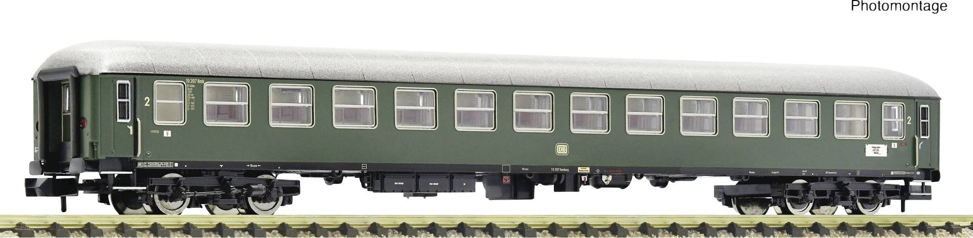 A green passenger carriage with a grey roof on railway tracks. Model of a second-class train coach.