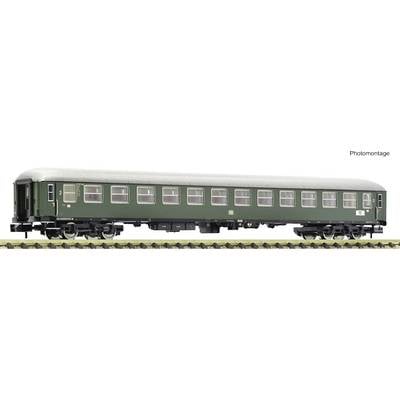 A green passenger carriage with a grey roof on railway tracks. Model of a second-class train coach.