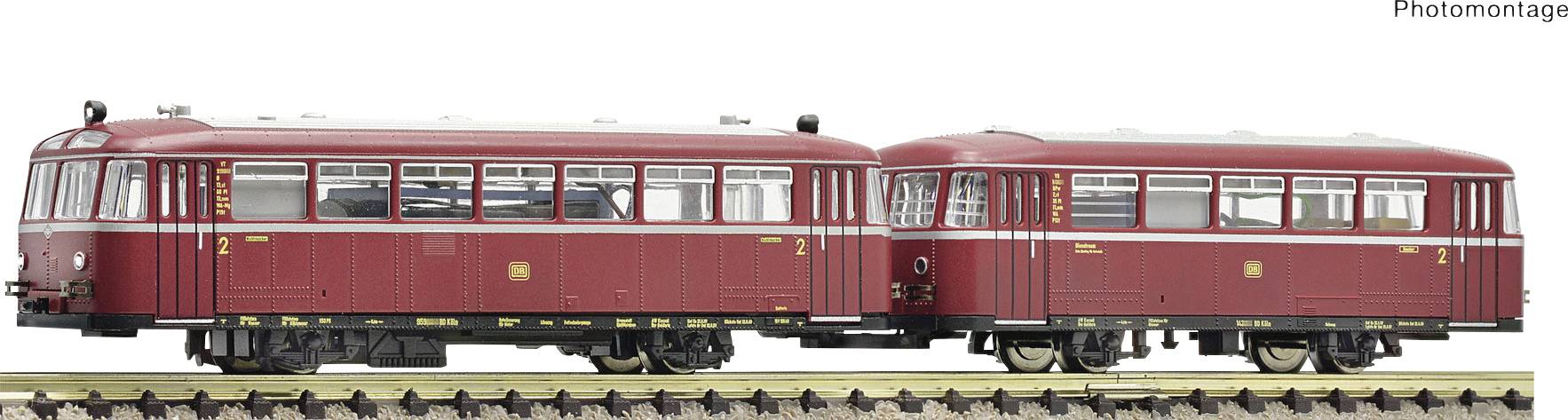Two red rail buses on a track. Both have white decorative stripes and multiple windows. Model railway with detailed equipment.