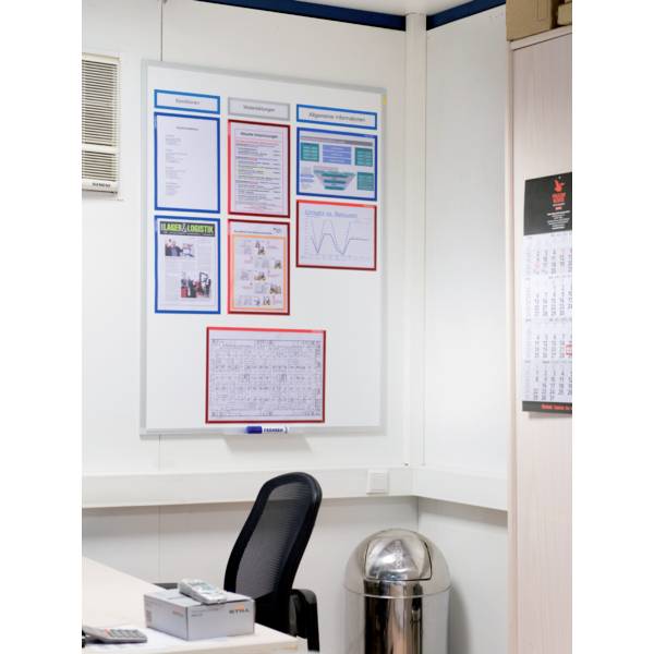 Office view: An empty office chair in front of a whiteboard mounted on the wall, displaying various diagrams, texts, and a calendar.