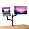 Two-screen setup on a desk: a laptop and a monitor mounted side by side. The monitor displays a landscape at sunset.