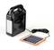 Black portable lamp with handle, connected to a small solar panel. Ideal for independent, solar-powered lighting.