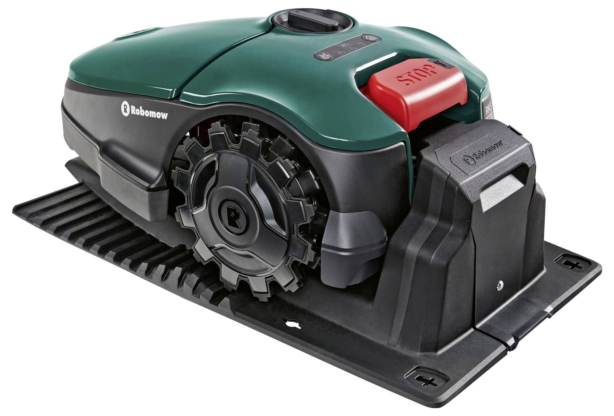 Robotic lawnmower in charging station, green-black, with red 'STOP' button.