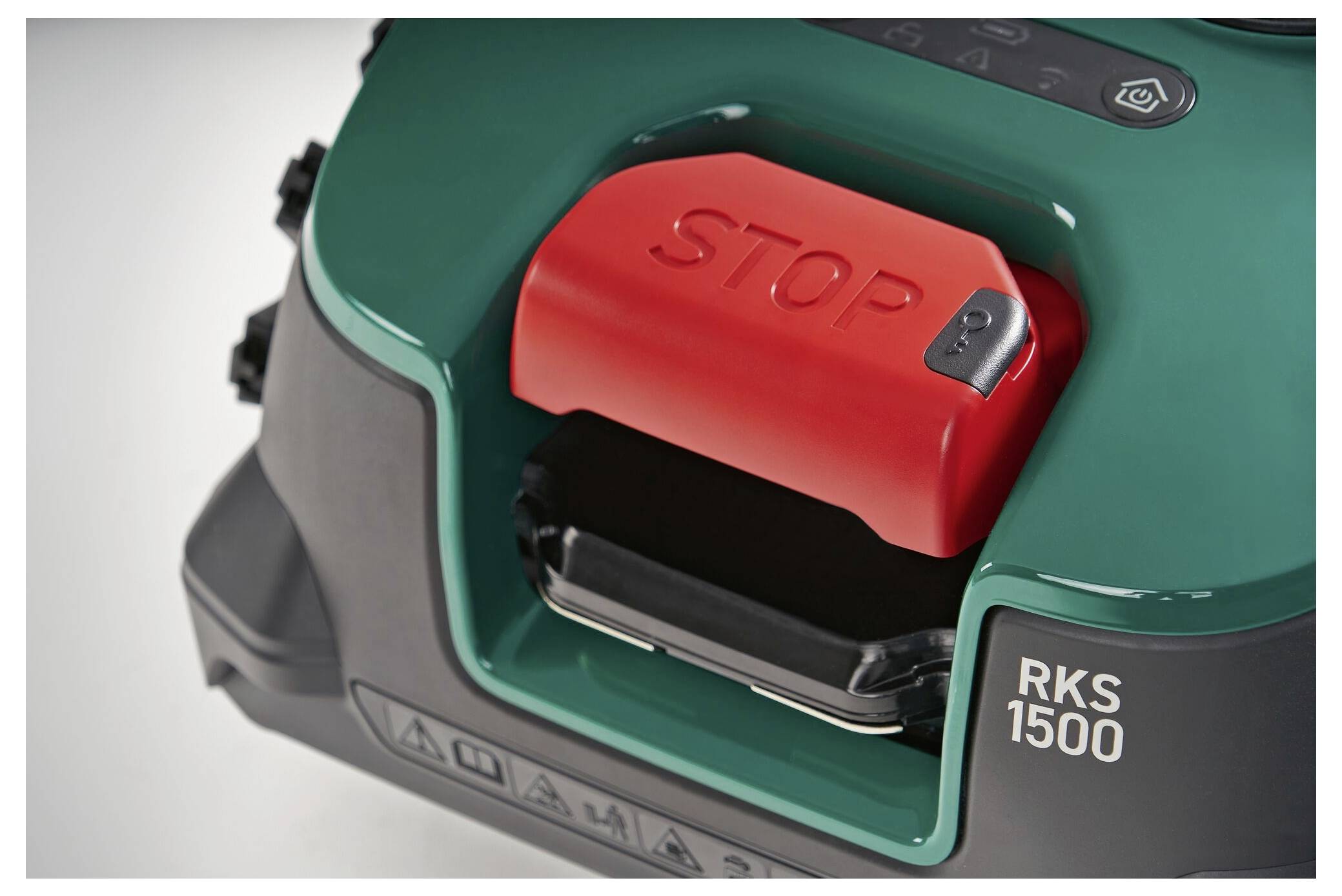 Red stop button on a green device with the inscription 'RKS 1500', likely a safety feature on a machine.