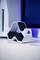 A white PlayStation controller station against a blue background, with part of a console visible on the left side of the image.