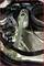 'A spanner is placed on a vehicle's engine component and points towards a screw or nut.'