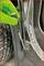A hand wearing a green glove, holding a screwdriver and fastening a screw to a metal component in a vehicle.