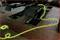A yellow hose lies on the floor of a car workshop next to a vehicle lift.