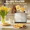 A toaster in a modern kitchen, two cheerful slices of toast popping out. Beside it sits a cup of coffee, a vase with yellow tulips, and a plate of toast. Text: 'Compact, stylish and ready for your morning!'