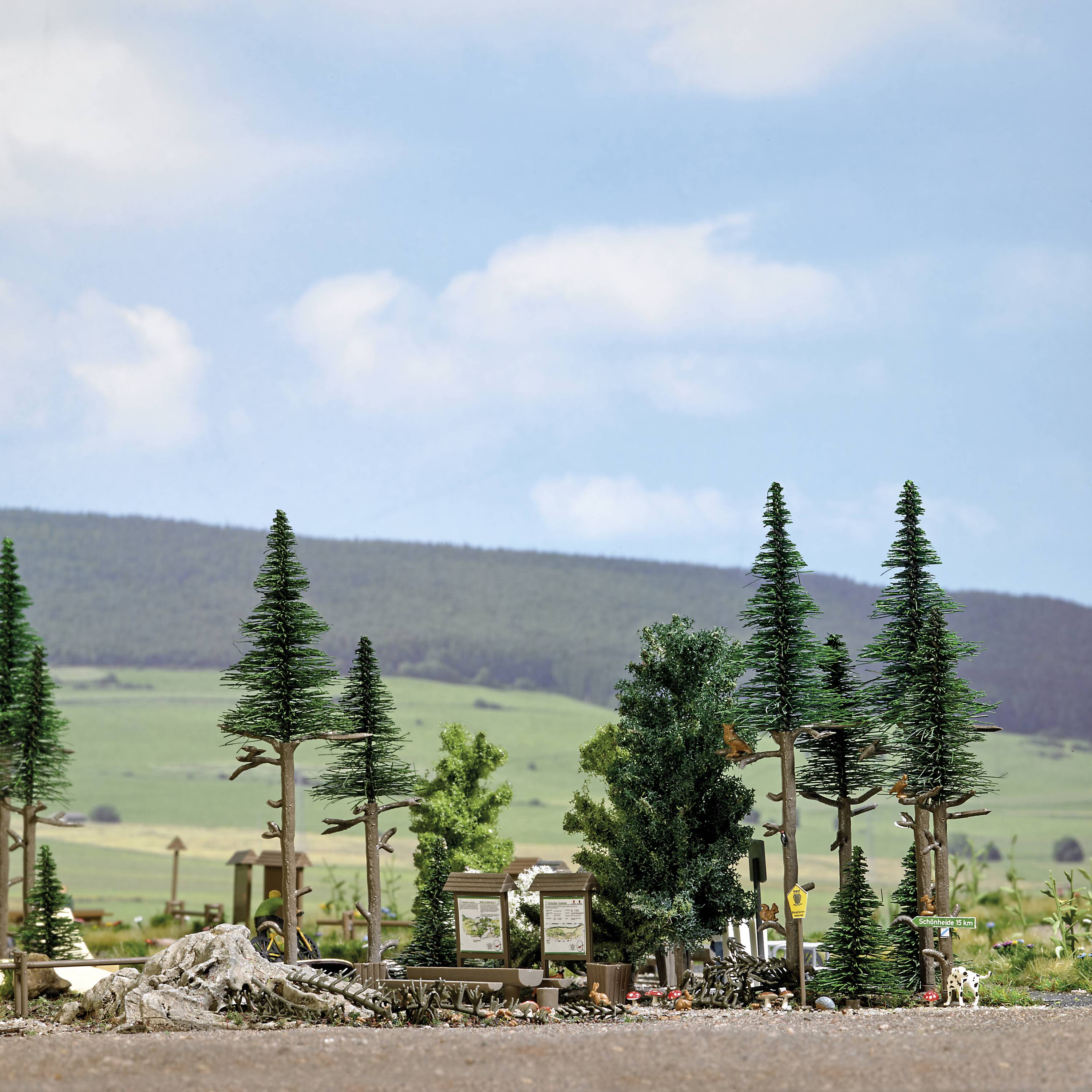 Miniature model of a landscape with trees, rocks, and a hill in the background.