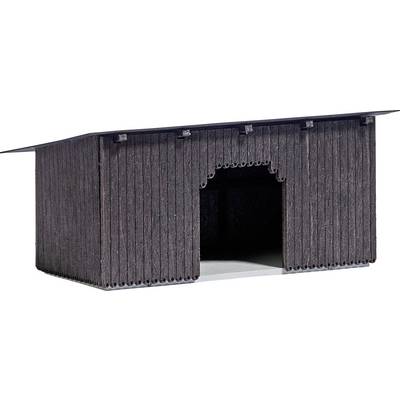 A small, dark wooden barn with a large archway in the middle.