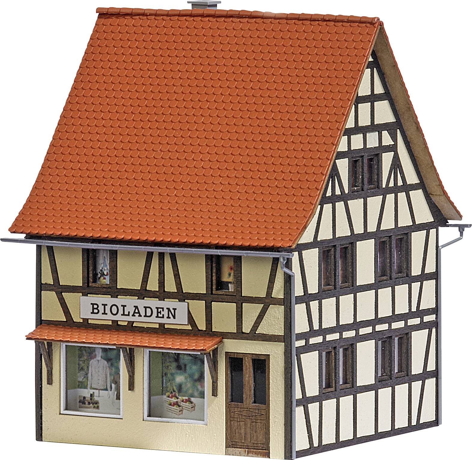 Half-timbered house with a red roof, labelled 'ORGANIC SHOP'. It has display windows with merchandise.