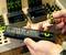 A person is holding a remote control powered by rechargeable AA batteries in front of a battery charger.