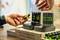 A person is removing a rechargeable battery from a charging station. Background note: 'Start recharging today and make a difference'.
