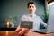 A person at a desk is holding a Verbatim external hard drive in front of the camera while working on a laptop.