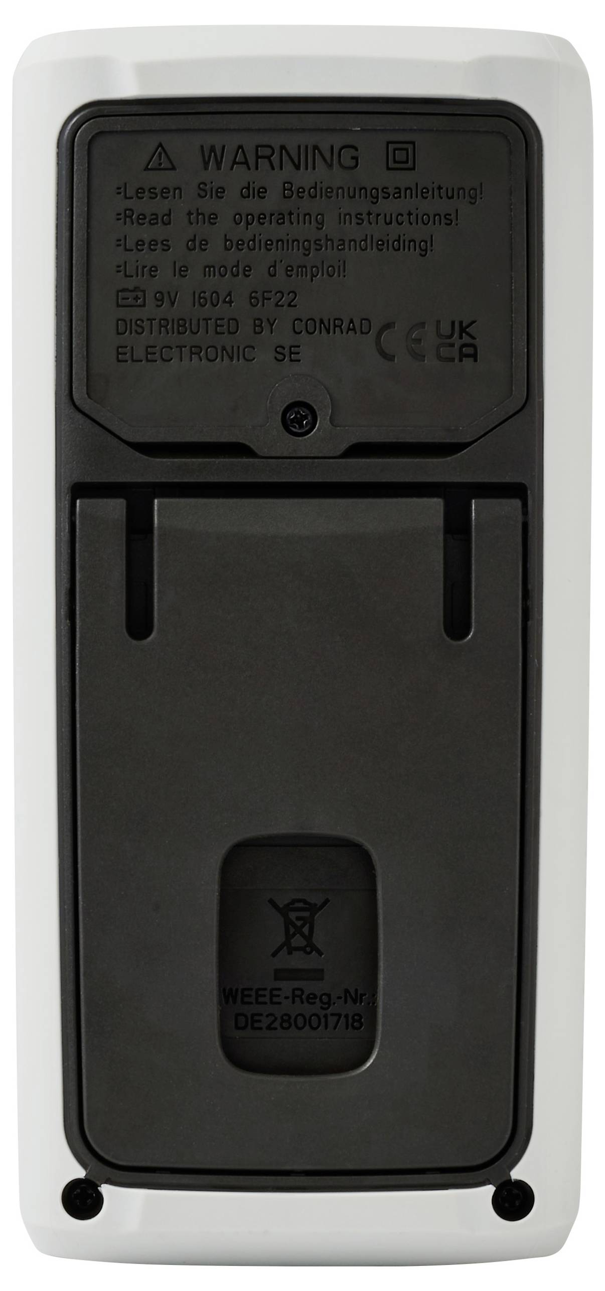 Back view of a remote control showing a warning label in multiple languages, battery compartment cover, and regulatory information.