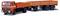 An orange lorry with a trailer is driving, with front lights switched on. The lorry has a Mercedes star on the radiator grille.