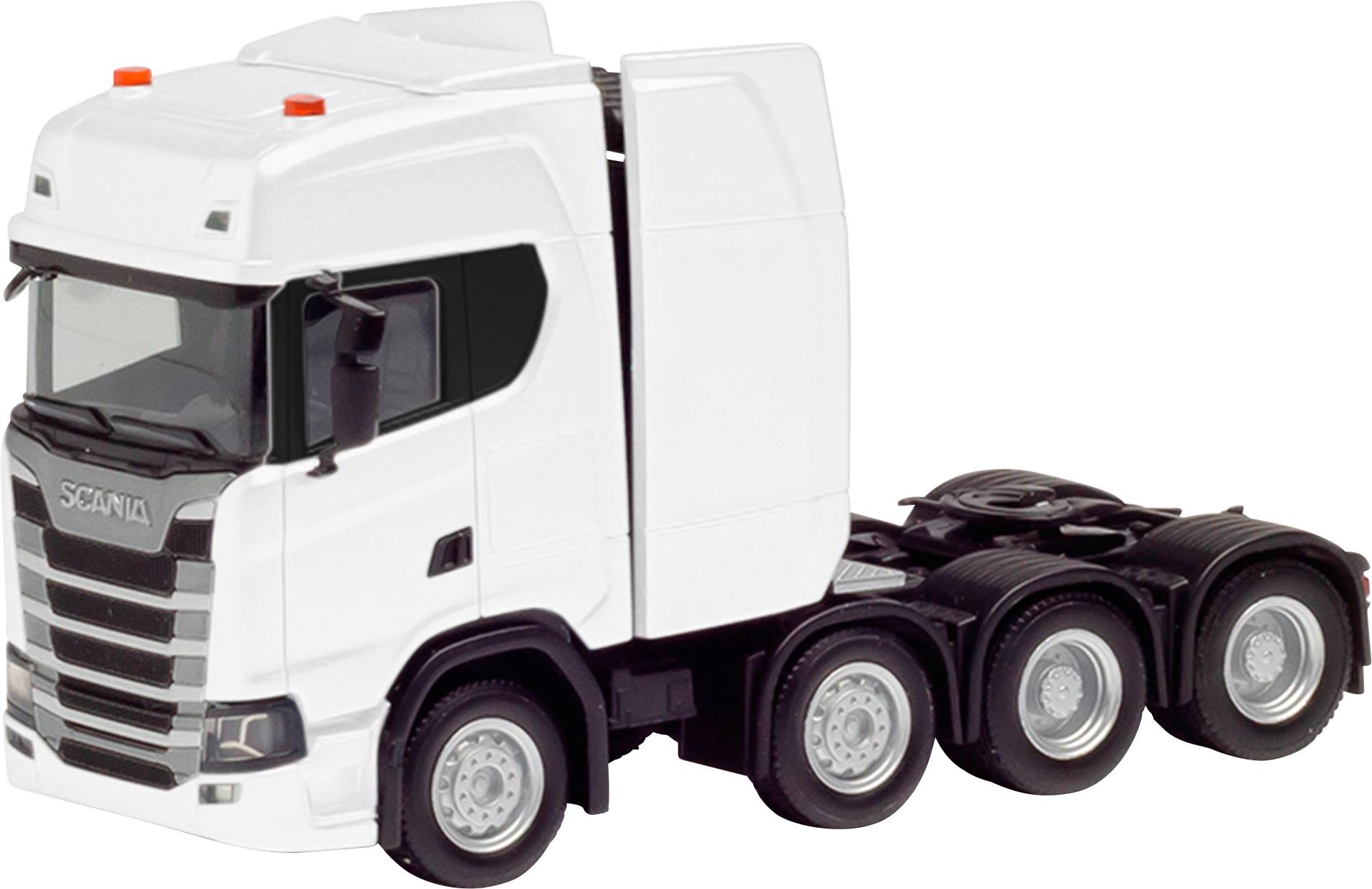 White truck with four rear tires, distinctive front grille and aerodynamic cab, standing on asphalt road.