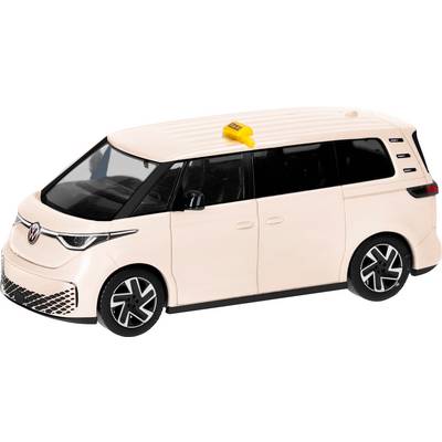 A cream-colored VW van with a yellow taxi sign on the roof, photographed from the side.
