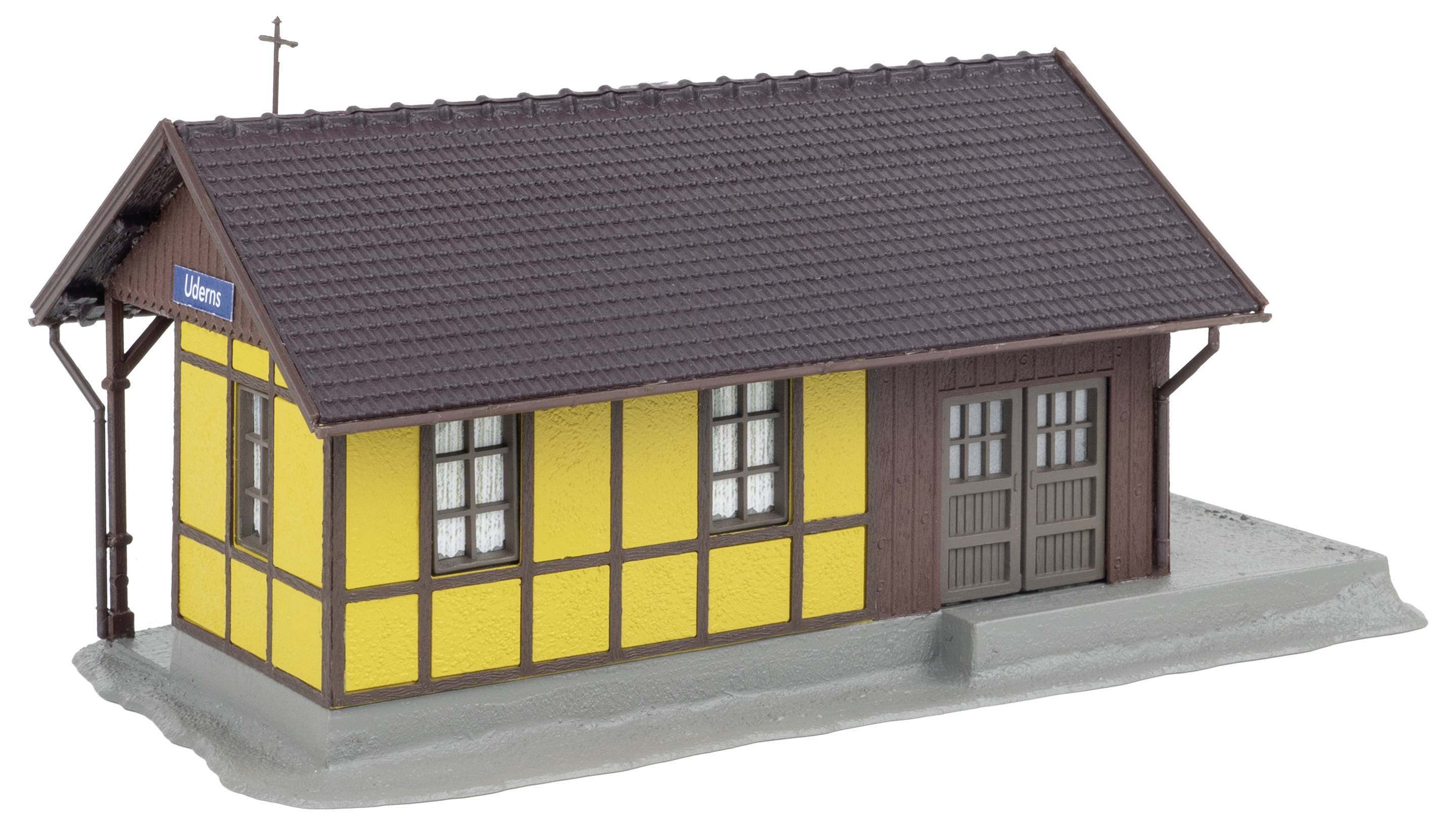 Yellow and brown half-timbered building with a cross on the roof and a sign 'Uhler' on the side.