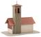 A model of a small church with a red tiled roof and tall bell tower. The building is positioned on a sand-coloured base.