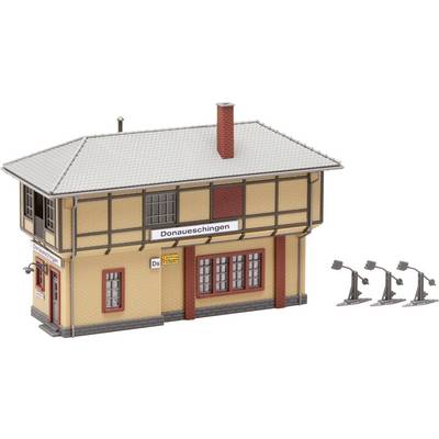 A model of a railway station building with the inscription 'Donaueschingen', light brown walls, red tiled roof, and four lamps on the side.