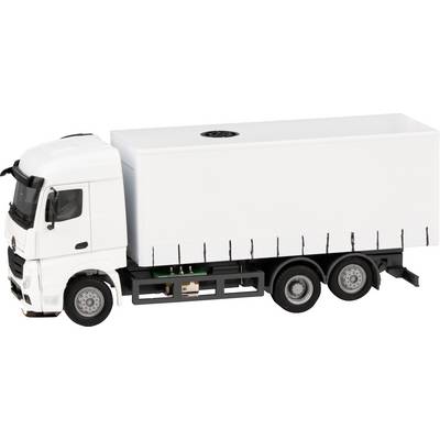 A white lorry with a closed box trailer on a smooth road. It is a model vehicle at a scale of 1:87.