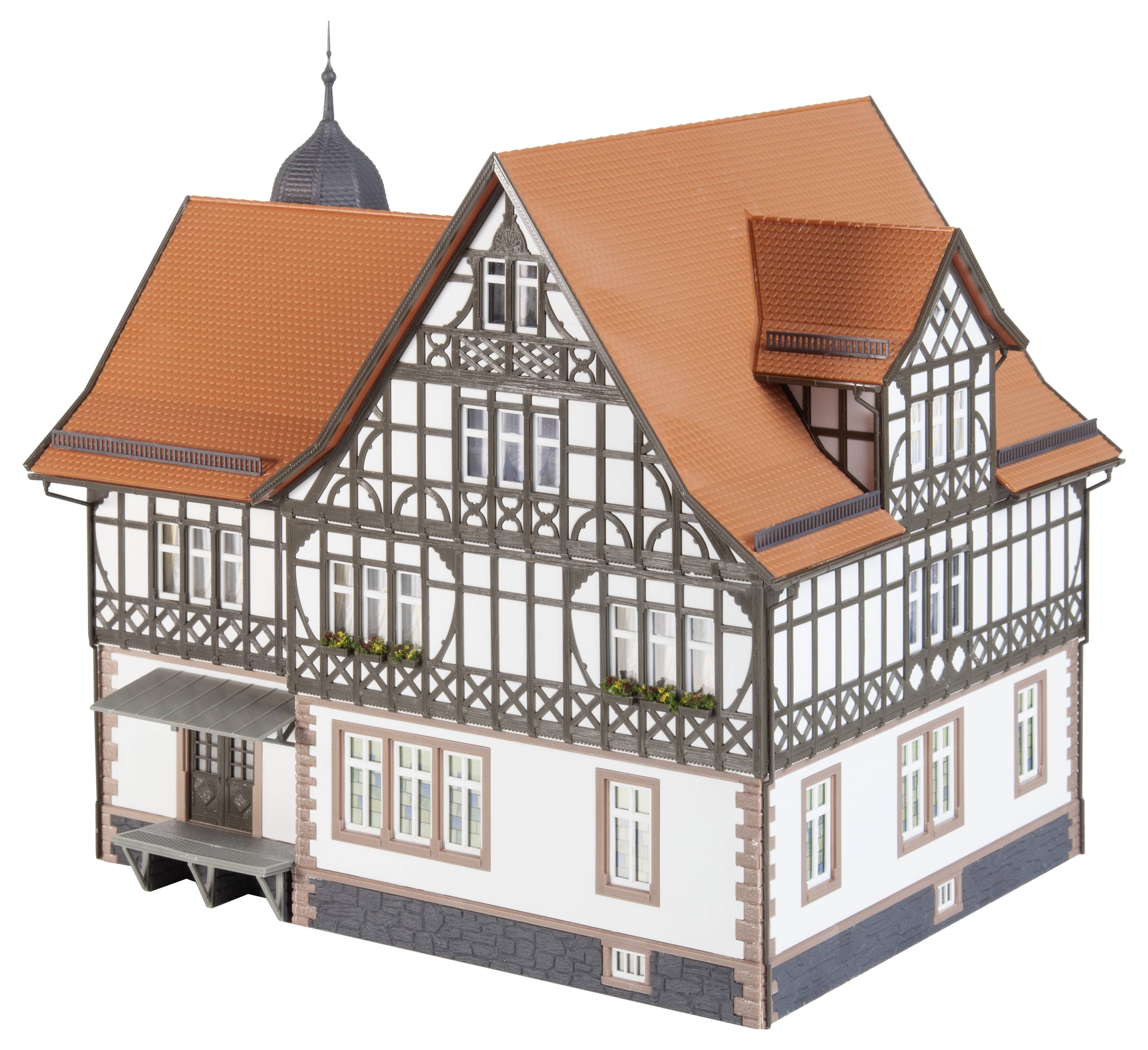 A half-timbered house model with a red tiled roof and dark brown wooden decorations, displaying detailed architecture and window flowers.