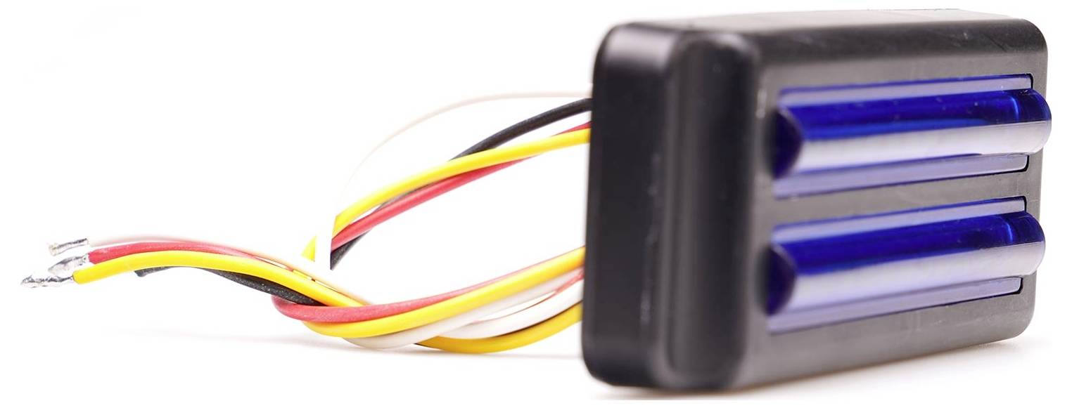 A detonator in a black casing with two blue tubes and protruding red, yellow and white wires.