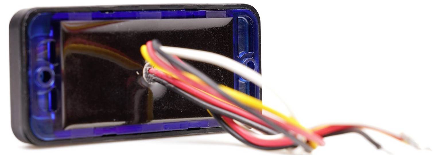 A small electronic component with several colourful cables protruding. Potentially part of a larger device.