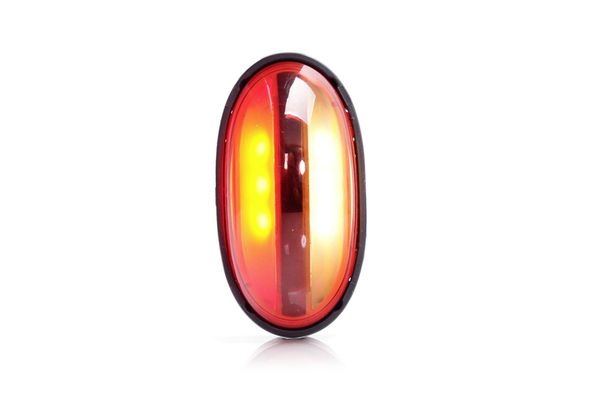 An oval, red LED rear light on a white background.