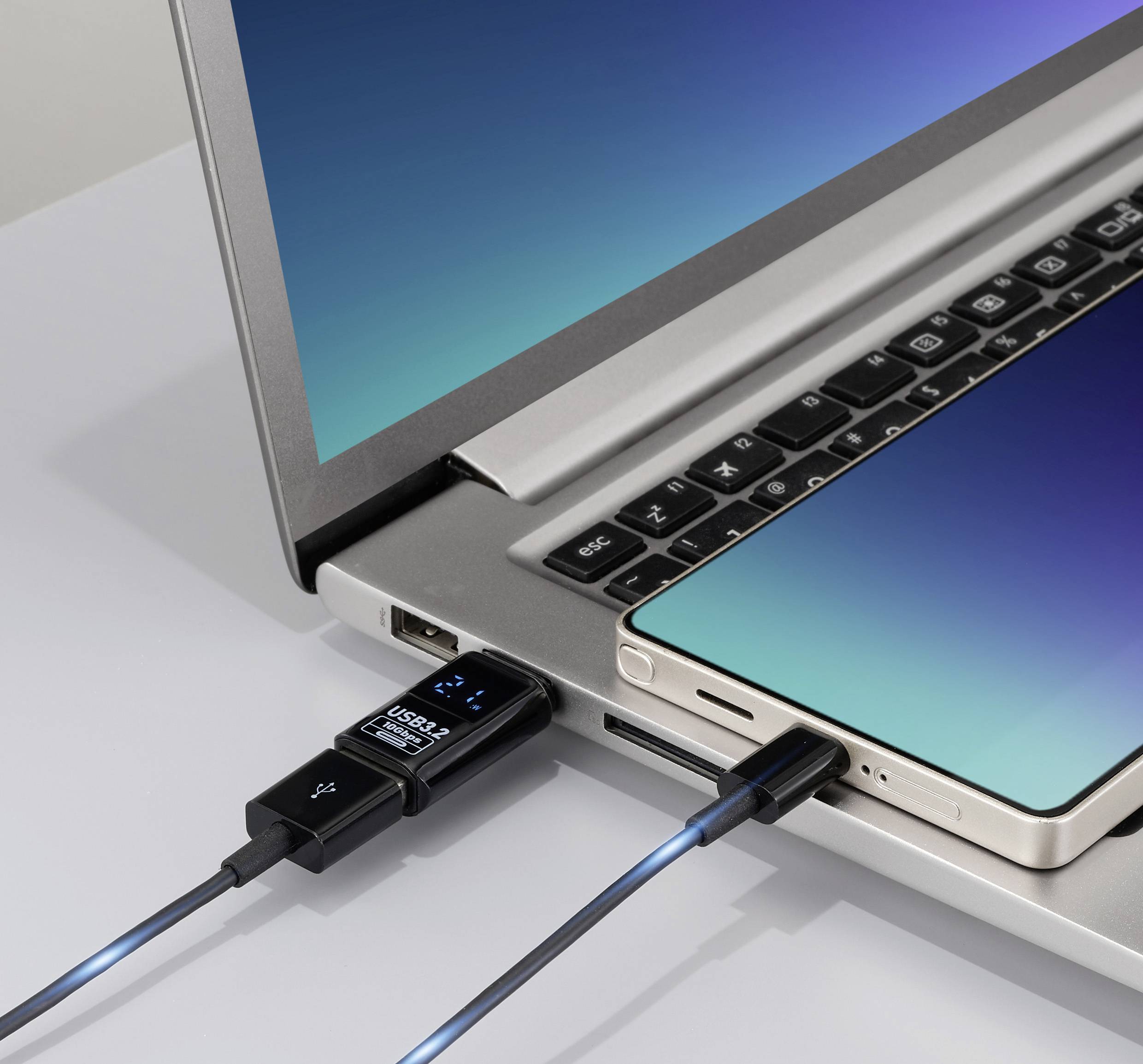 A smartphone is connected to a laptop via a USB cable, indicating data transfer or charging. Both devices are turned on.