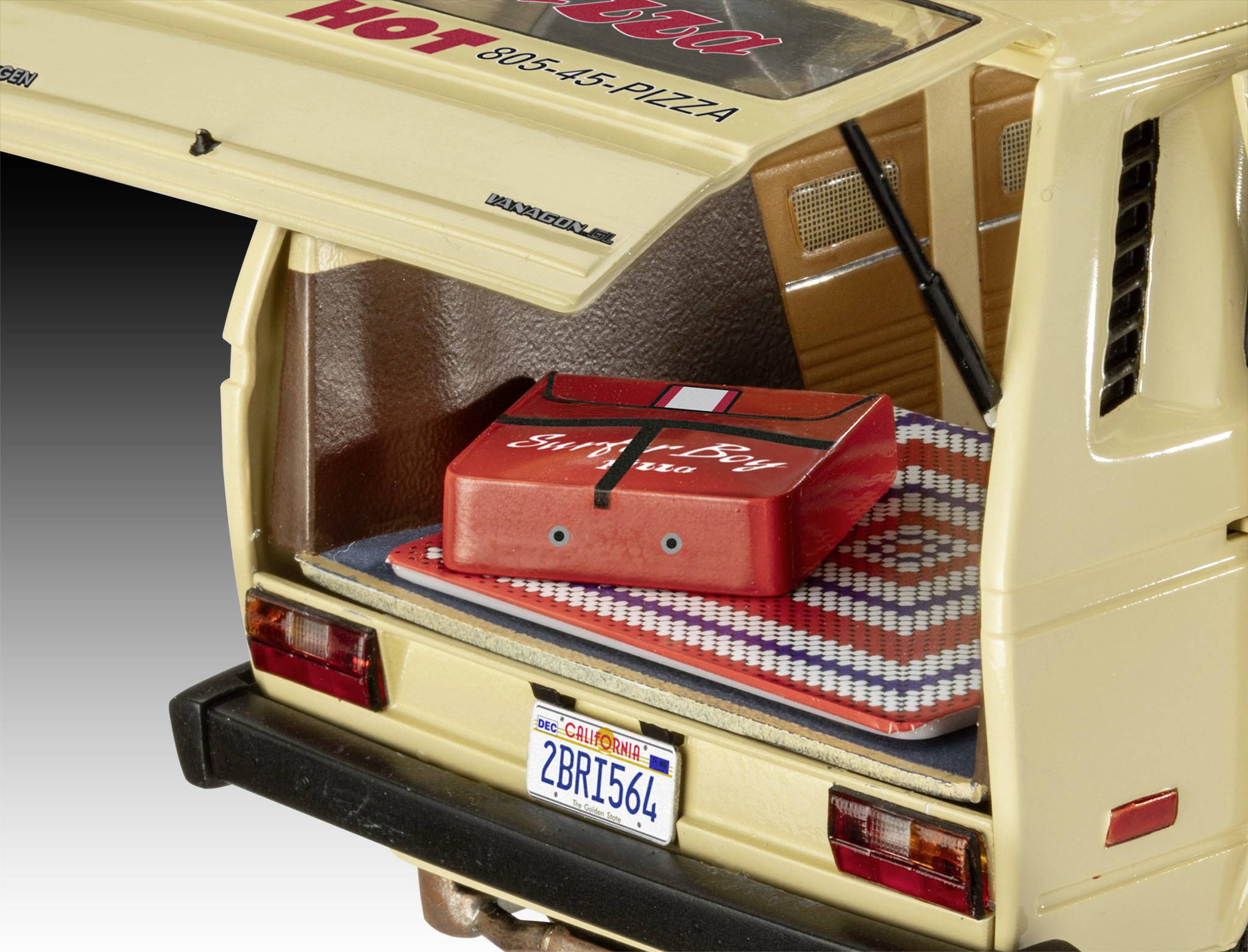 An open boot of a delivery van with a pizza box on a checked blanket. The number plate reads '2BRT564'.