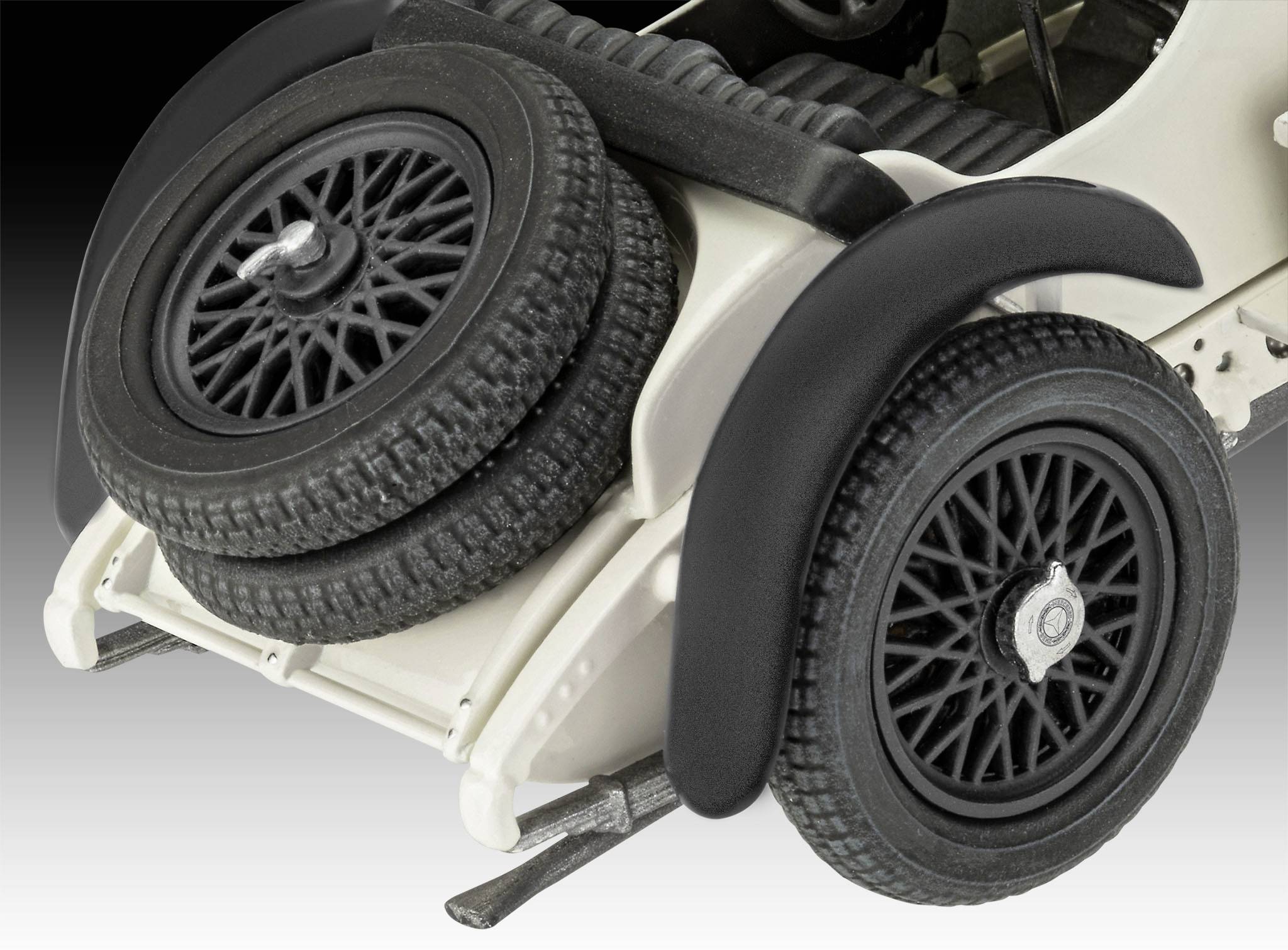 A vehicle model shows the rear of an old car with two spare tyres mounted on the boot, and black mudguards.