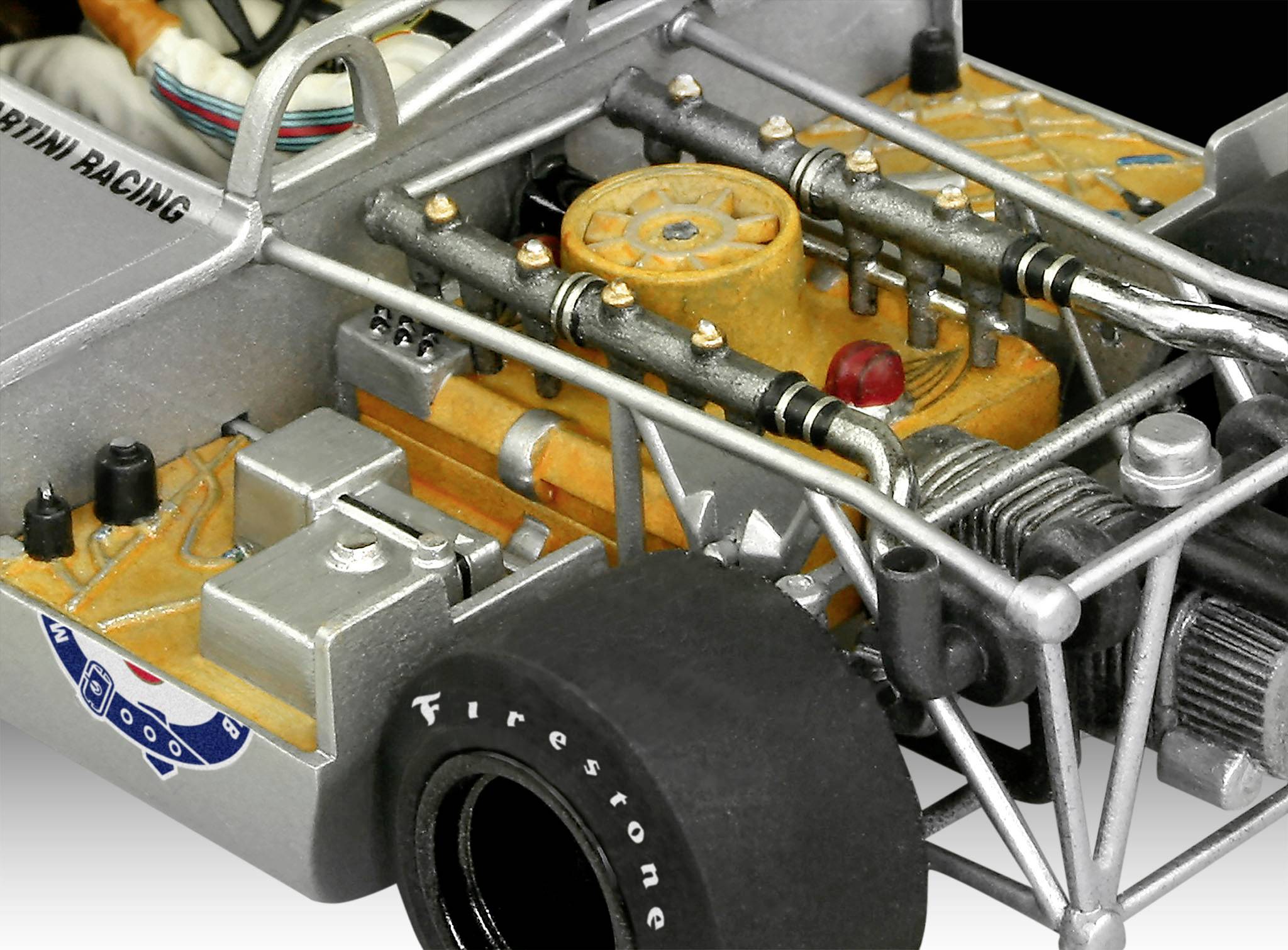 Close-up of a vintage racing car model. The engine and chassis details with 'Firestone' tyres are visible.