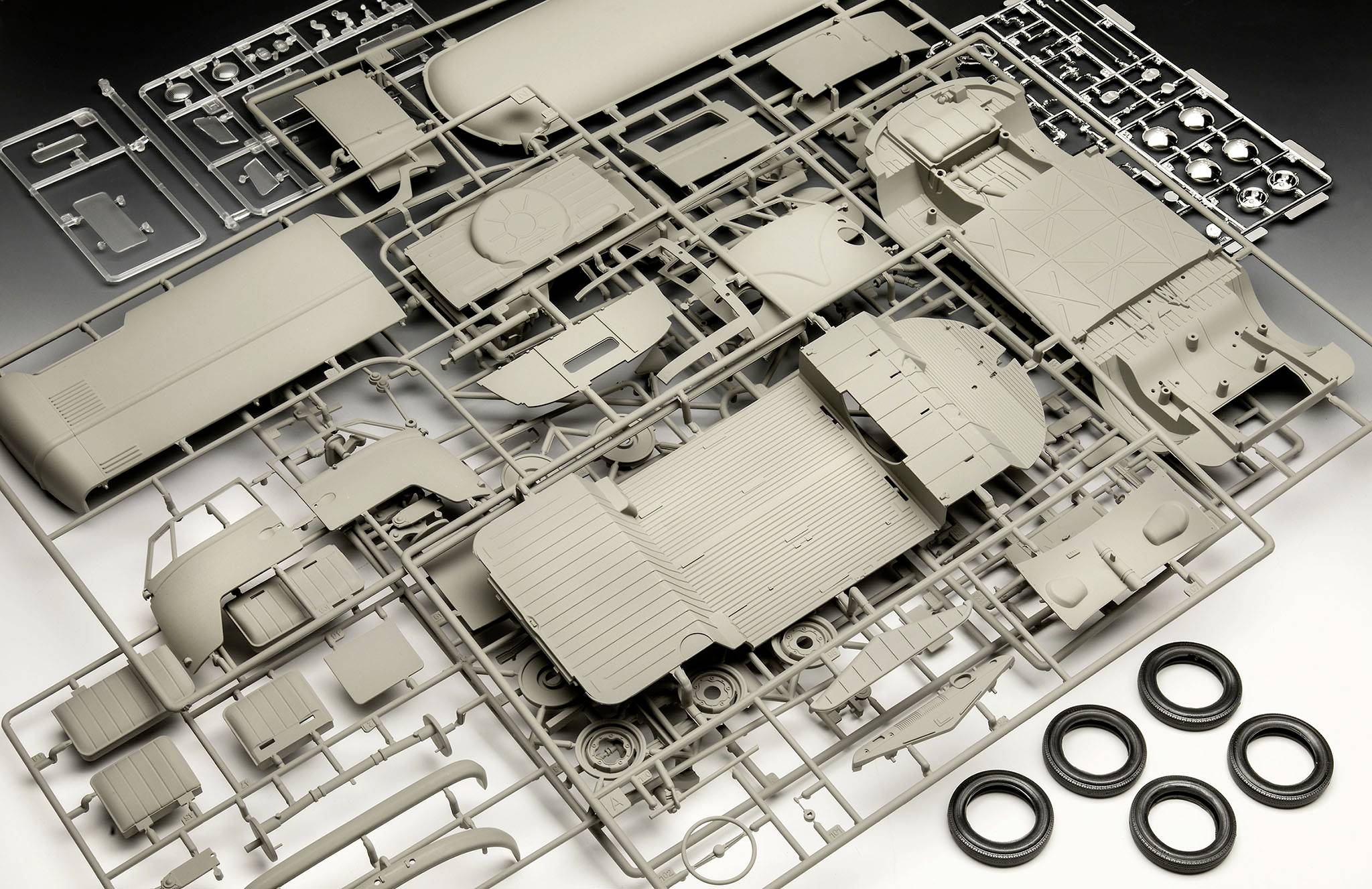 Parts of a model truck kit, including wheels and body components, arranged in a plastic frame.