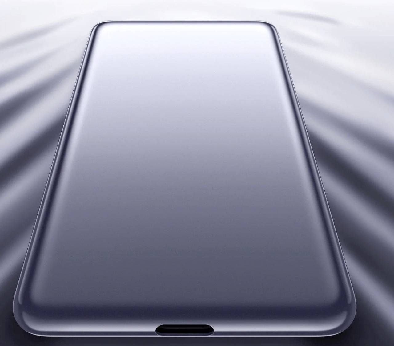 A sleek, modern smartphone with a large screen, shown from an angled top-down perspective on a reflective surface.