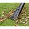 A leaf blower with a rake removes brown leaves from a green lawn.