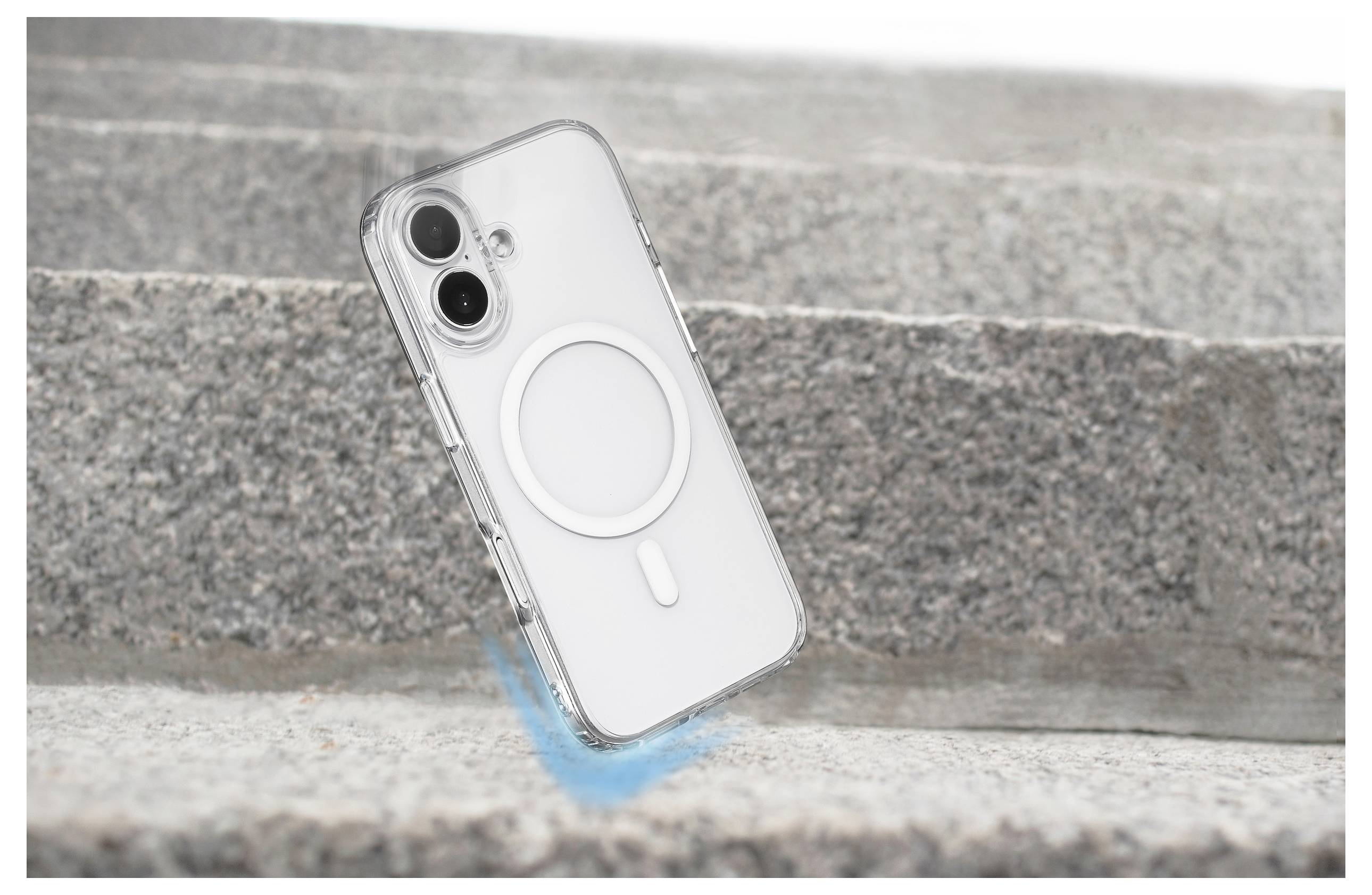 A white smartphone with a transparent case displaying a circular MagSafe design is angled on stone steps, suggesting motion and durability.