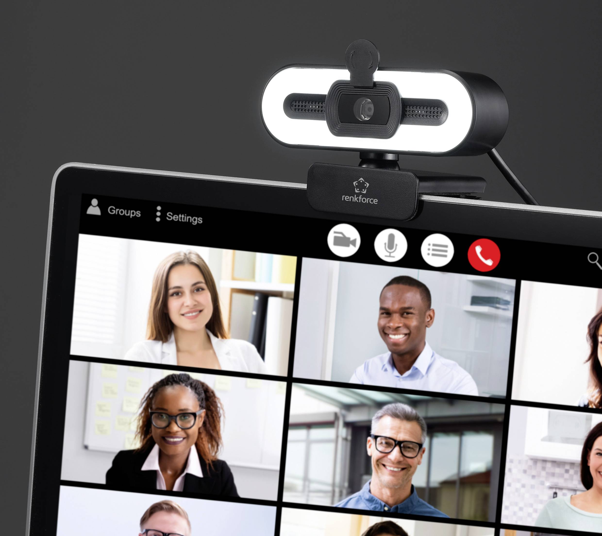 A video conference screen shows eight diverse people smiling, each in their own box. A webcam with a circular light is positioned above the screen.