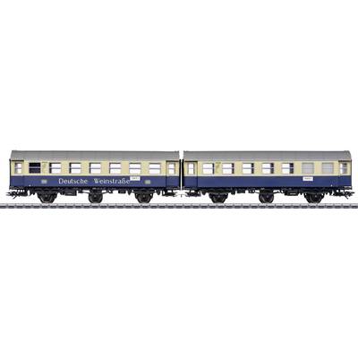 Two historic railway carriages with the inscription 'Deutsche Weinstraße', painted in blue and yellow, on a railway track.