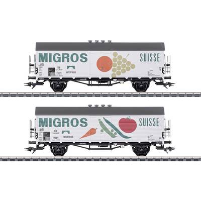 Two refrigerated wagons labelled 'Migros' and 'Suisse'. Top: Grape and apple. Bottom: Tomato and pea. Transportation of foodstuffs.
