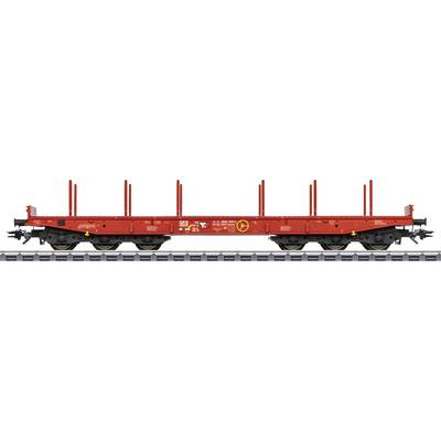 A red goods wagon with side stakes on railway tracks, unloaded. Suitable for transporting long goods such as timber logs.