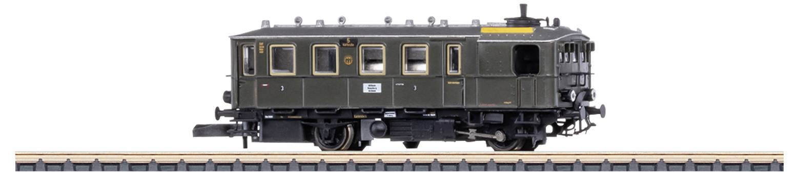 A green, detailed model train carriage on a track, photographed from the side. The carriage has windows and labelling.