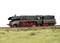 A green model of a steam locomotive with red wheels on a track, surrounded by grass.