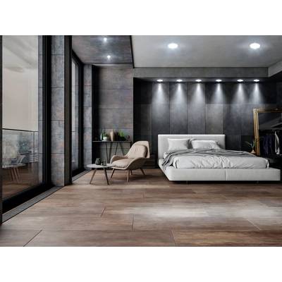 A modern bedroom with a gray bed, an armchair and table, large windows and indirect lighting. Elegant design.